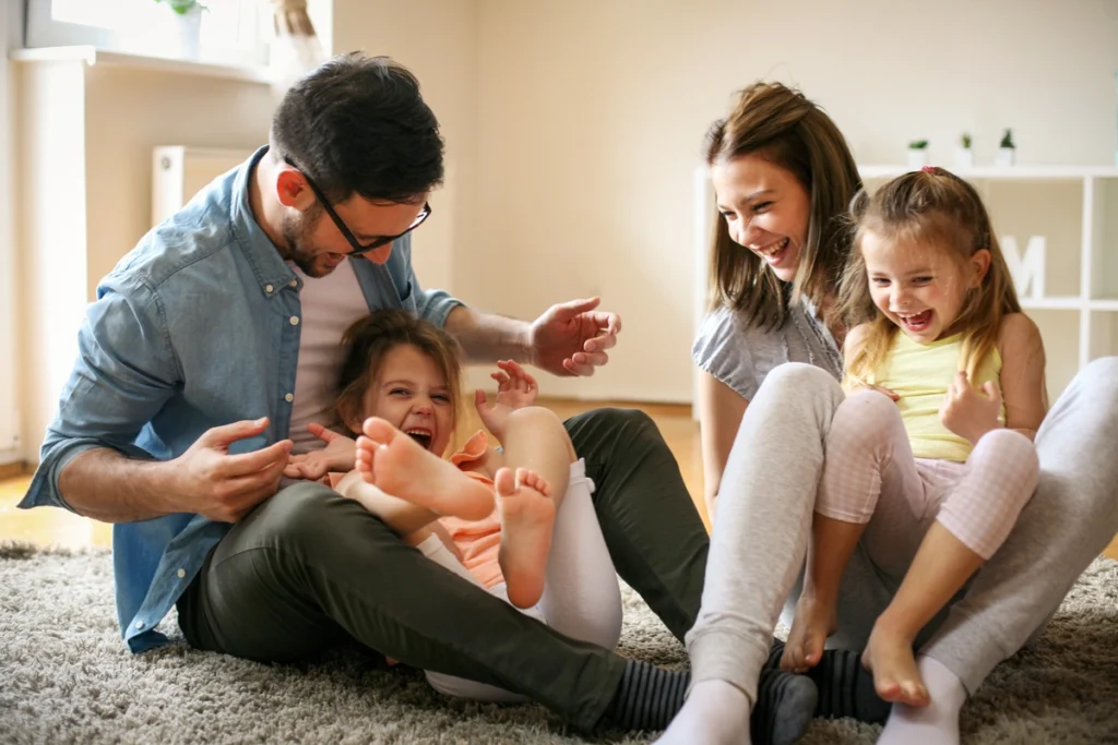 family of four laughing together at home